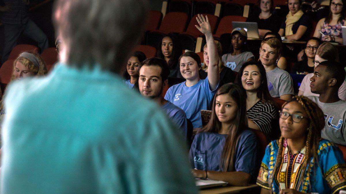 A student raises her hand in class.