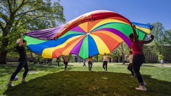 People holding rainbow-colored tarp