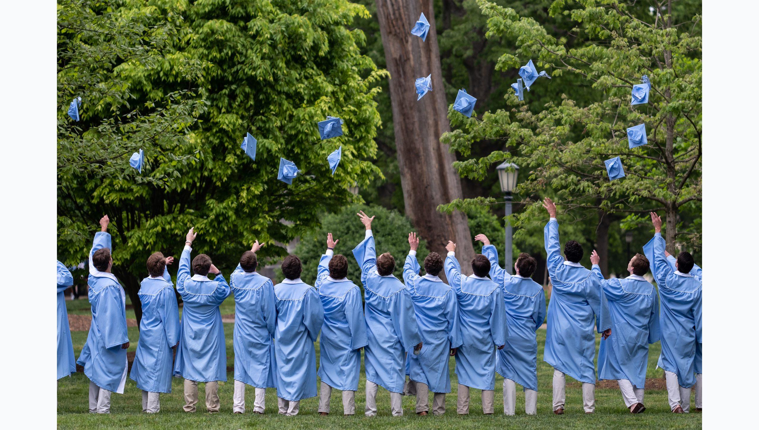 一群学生在他们的集体毕业照中，戴着皇冠向空中投掷帽子.